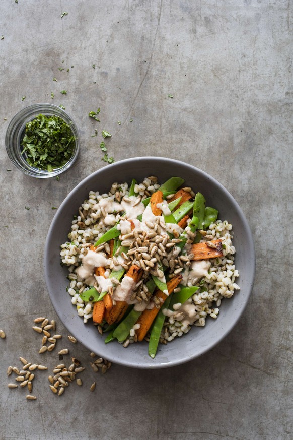 This undated photo provided by America&#039;s Test Kitchen in June 2019 shows a Barley Bowl with Roasted Carrots and Snow Peas in Boston. This recipe appears in the cookbook &quot;Vegan for Everybody. ...