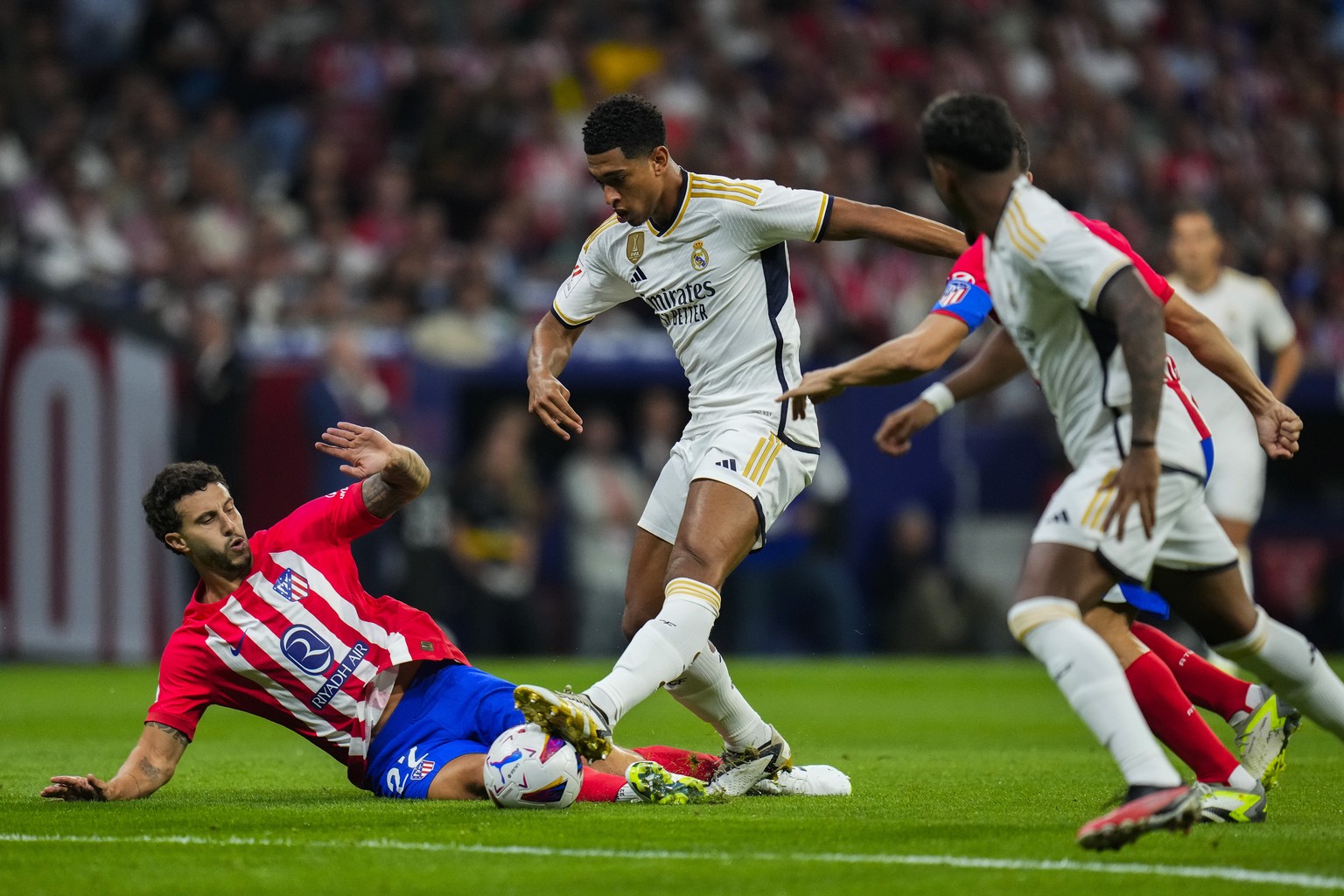 Real Madrid&#039;s Jude Bellingham, right, attempts a shot on goal challenged by Atletico Madrid&#039;s Mario Hermoso during the Spanish La Liga soccer match between Atletico Madrid and Real Madrid at ...
