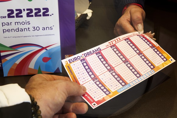 Un membre de la loterie romande presente le nouveau jeu de la loterie romande EURODRAMS a Josephine, kiosquiere, avant son lancement, ce lundi 16 octobre 2023 a Cheseaux-sur-Lausanne pres de Lausanne. ...