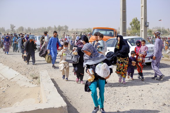 epa09420841 A handout photo made available by Iranian Red Crescent shows Afghan refugees gather in Iran-Afghanistan border in Sistan-Blochestan province, south-eastern Iran, 16 August 2021 (issued 19  ...