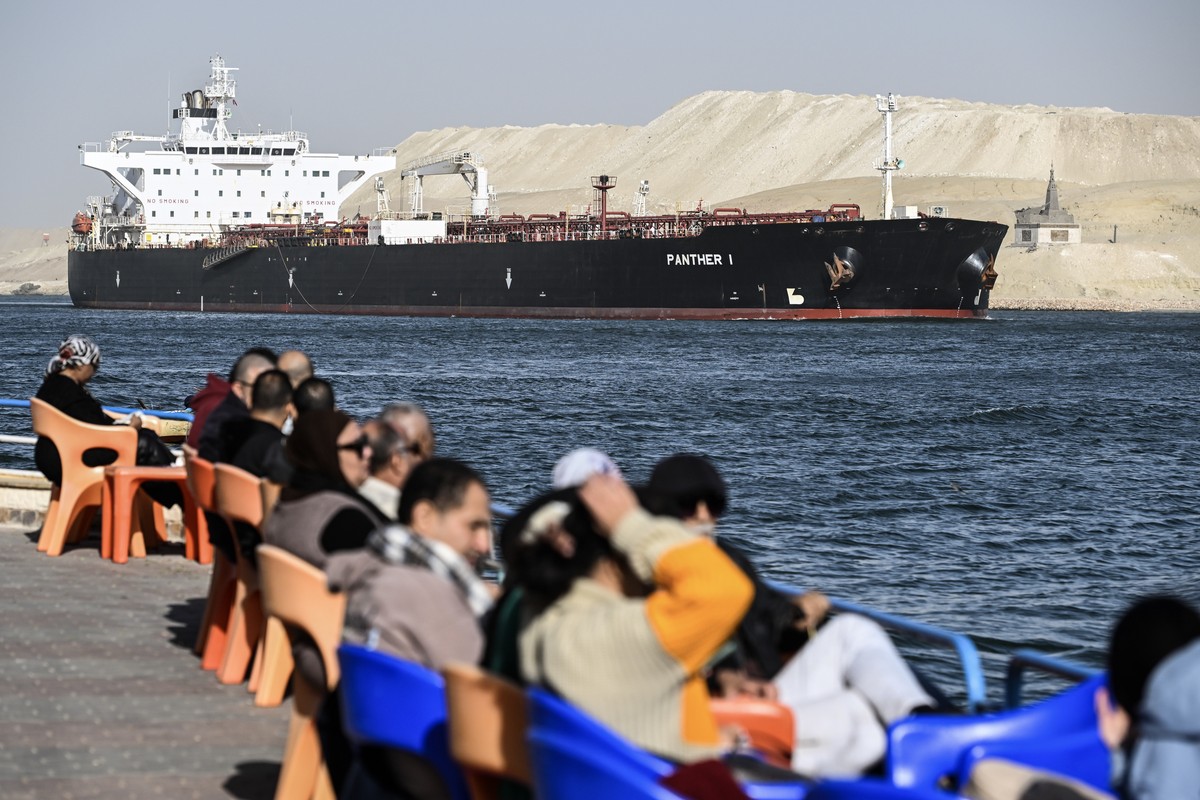 epa11040961 People watch as a ship crosses the Suez Canal towards the Red Sea in Ismailia, Egypt, 22 December 2023. On 18 December, the US Department of Defense announced a multinational operation to  ...