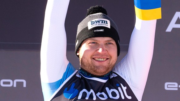 epa09800972 Niels Hintermann (L) of Switzerland and Cameron Alexander (R) of Canada, both sharing first place, celebrate on the podium after winning the men&#039;s Downhill race of the FIS Alpine Skii ...