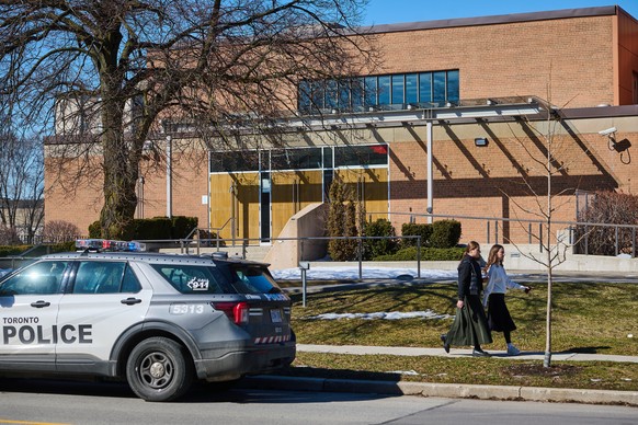Pedestrians pass by a police car parked outside Shaarei Shomayim synagogue in Toronto, on Sunday, March 8, 2026. (Sammy Kogan/The Canadian Press via AP)
Canada Synagogue Shooting