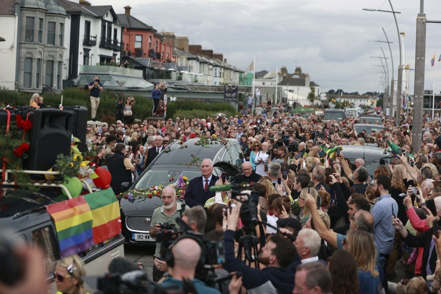 Fans of Sinead O&#039;Connor line the street as her funeral cortege passes through her former hometown of Bray, Co Wicklow, Ireland, Tuesday, Aug. 8, 2023. O?Connor?s family invited the public to line ...