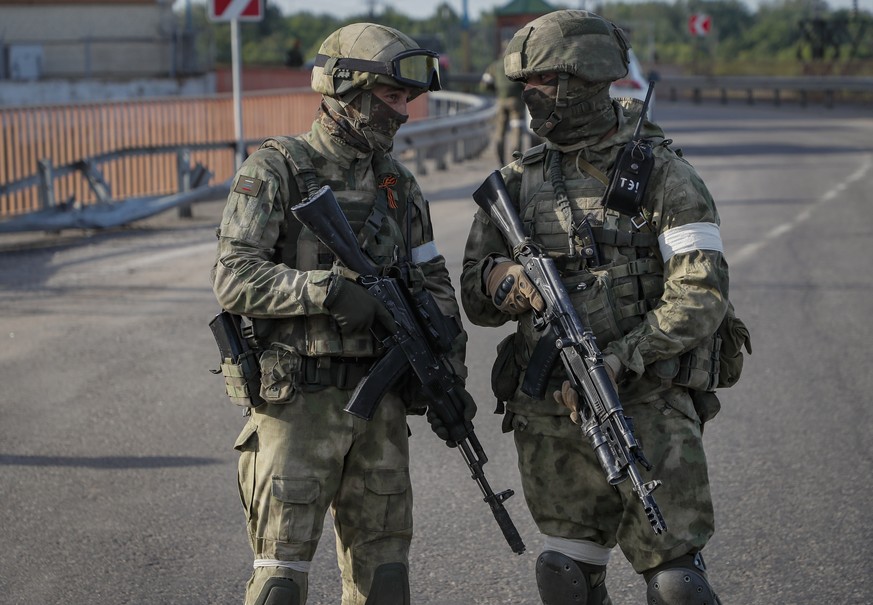 epa09962109 A picture taken during a media tour organized by the Russian Army shows Russian servicemen standing guard near the Kakhovka Hydroelectric Power Plant (HPP) on the Dnieper River in Kakhovka ...