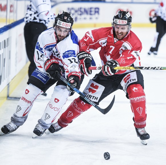 Suisse player Luca Cunti, left, fights for the puck with David McIntyre during the final game between Team Canada and Team Suisse at the 91th Spengler Cup ice hockey tournament in Davos, Switzerland,  ...