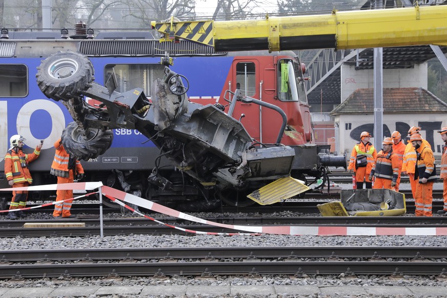 Bahnarbeiter heben mit einem Kran ein verunfalltes Baustellenfahrzeug von den Geleisen, am Dienstag, 7. Februar 2017, beim Bahnhof Winterthur. Bei der Kollision mit einem Gueterzug im Bahnhof Winterth ...