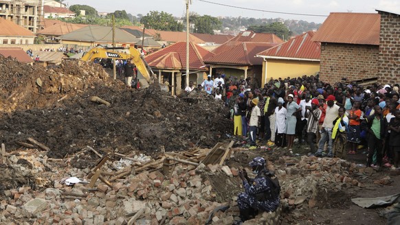Onlookers watch as workers search for survivors at the site of a collapsed landfill in Kampala, Uganda, Sunday, Aug. 11, 2024. (AP Photo/Hajarah Nalwadda)