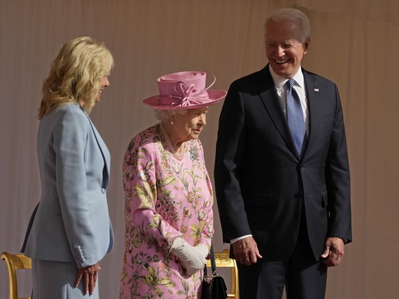 FILE - In this June 13, 2021 file photo US President Joe Biden and First Lady Jill Biden smile while standing with Britain&#039;s Queen Elizabeth II watching a Guard of Honour march past before their  ...