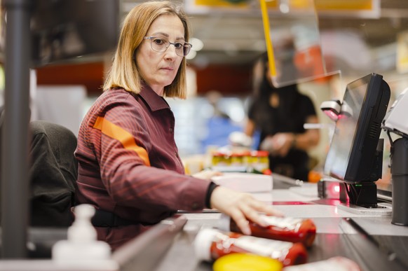 Die Verkaeuferin Stefania Kaufmann bedient eine Kundin bei ihrem Einkauf in der Migros am Limmatplatz, am Donnerstag, 17. Februar 2022 in Zuerich. Der Bundesrat hebt per Donnerstag fast alle Corona-Ma ...