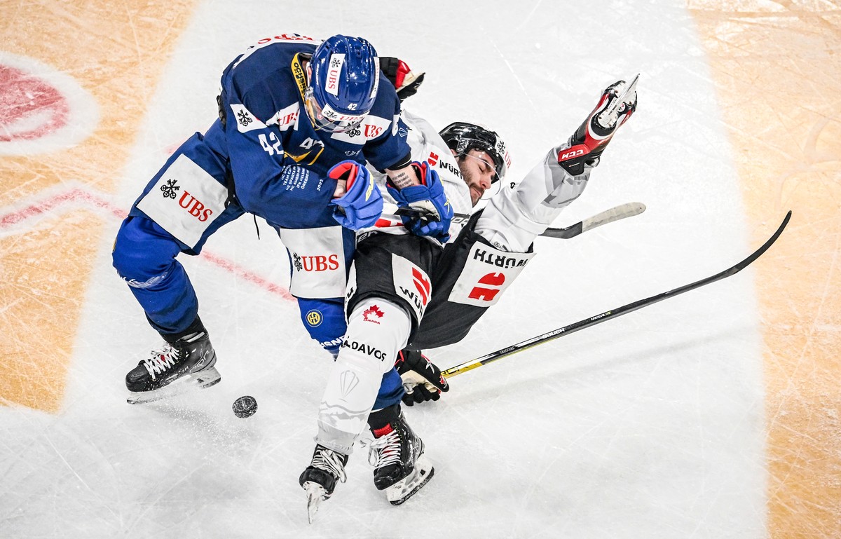 epaselect epa10379439 Davos' Joakim Nordstrom (L) in action against Canada`s Thomas Gregoire during the match between Switzerland`s HC Davos and Team Canada at the 94th Spengler Cup ice hockey to ...