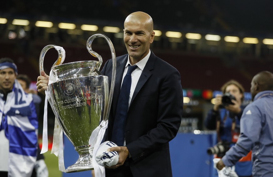 Real Madrid&#039;s head coach Zinedine Zidane holds the trophy after the Champions League soccer final between Juventus and Real Madrid at the Millennium Stadium in Cardiff, Wales, Saturday, June 3, 2 ...