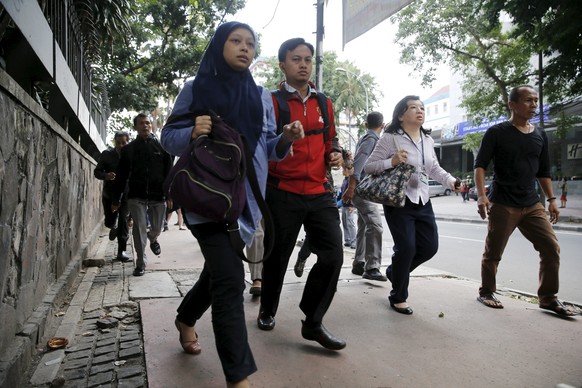 Indonesian workers run as they are evacuated from their office at Thamrin business district in Jakarta January 14, 2016. Several explosions went off and gunfire broke out in the center of the Indonesi ...