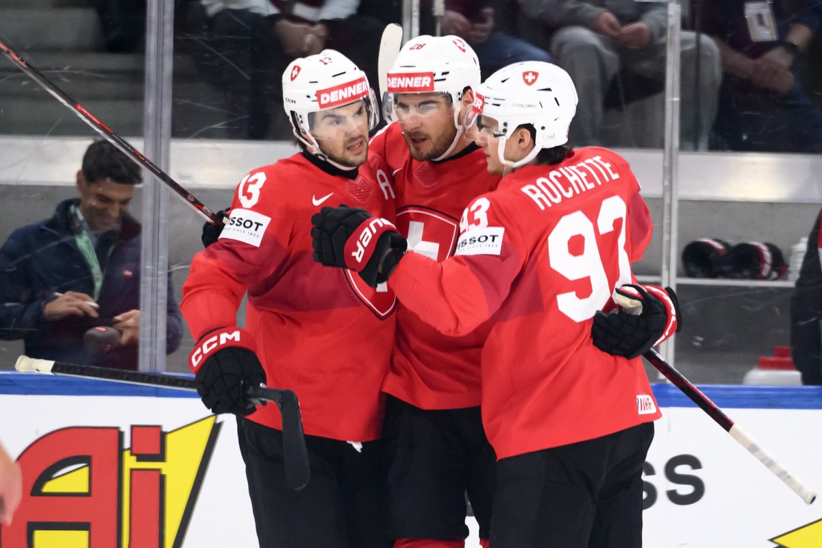 Switzerland's Nico Hischier, left, Switzerland's Timo Meier, center, and Switzerland's Theo Rochette, right, celebrate the first teams goal during the 2026 IIHF Men's Ice Hockey Wo ...