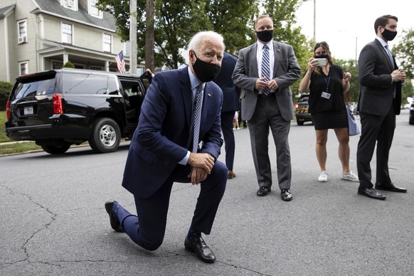 Democratic presidential candidate and former Vice President Joe Biden kneels down to talk to children on a street corner on North Washington Avenue in the Green Ridge section of Scranton, Pa., after v ...