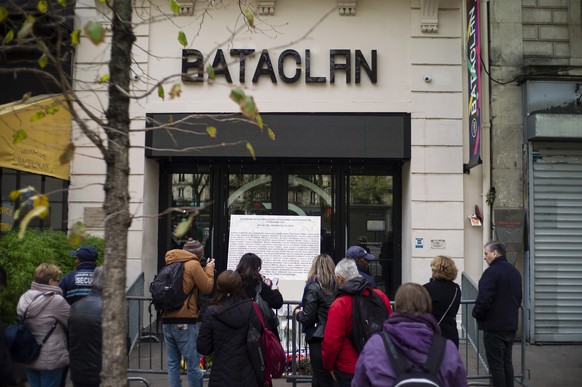 epa07992913 People pay their respect at the entrance of the Bataclan concert venue after a ceremony marking the fourth anniversary of the Paris attacks of November 2015, in Paris, France, 13 November  ...