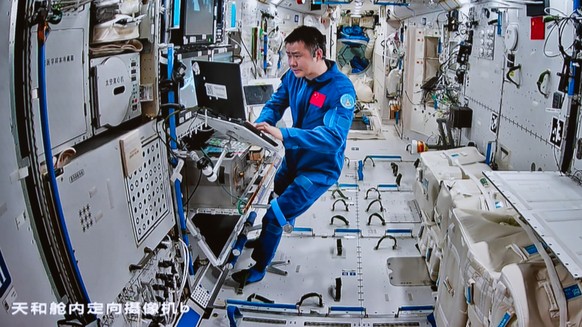 epa12406551 A screen image captured at the Beijing Aerospace Control Center shows Shenzhou-20 astronaut Chen Dong working inside China?s space station on 25 September 2025 (issued 26 September 2025).  ...
