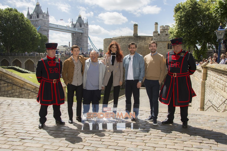 Tower of London Yeomen Warders, far left and far right, stand alongside actors Tom Holland, from left, Jacob Batalon, Zendaya, Jake Gyllenhaal, and Director Jon Watts as they pose for photographers up ...