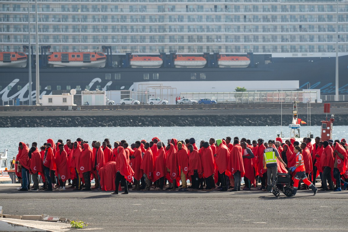 epa11796011 Red Cross members help some of the 240 migrants that have been rescued by Rescue Navy when they tried to reach the coast of Canary Islands by boats, at the docks in Arrecife, Lanzarote, Ca ...
