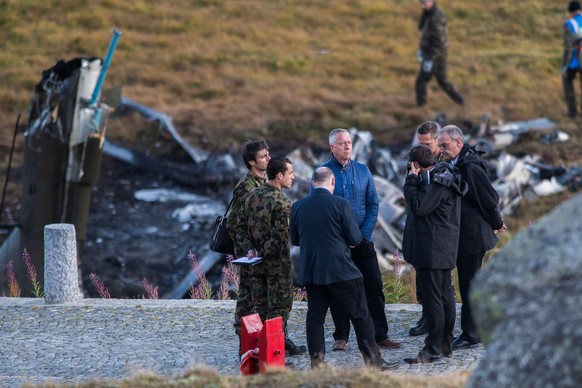 Andre Blattmann, Chief of the Armed Forces, center, and Federal Councillor Guy Parmelin, right, stand in front of the debris from a crashed Swiss army helicopter of the tipe Super Puma near the fort S ...