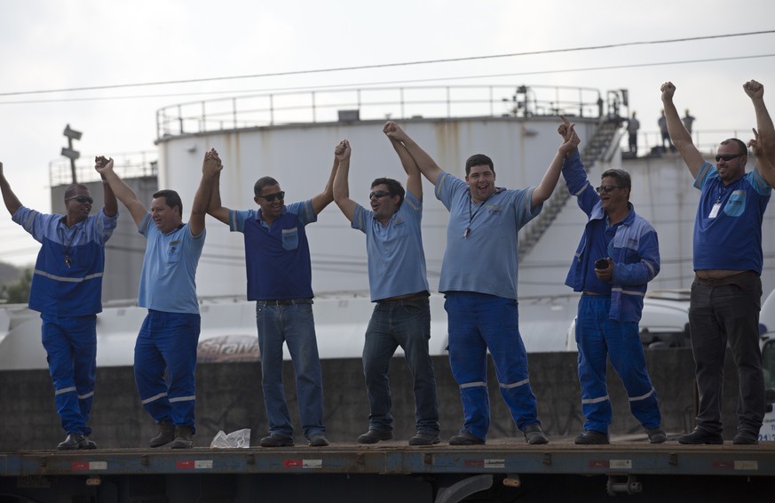 Striking truckers stand on the bed of a cargo truck as they protest rising fuel costs on the highway BR-040, in Duque de Caxias, Brazil, Thursday, May 24, 2018. A truckers&#039; strike is snarling tra ...