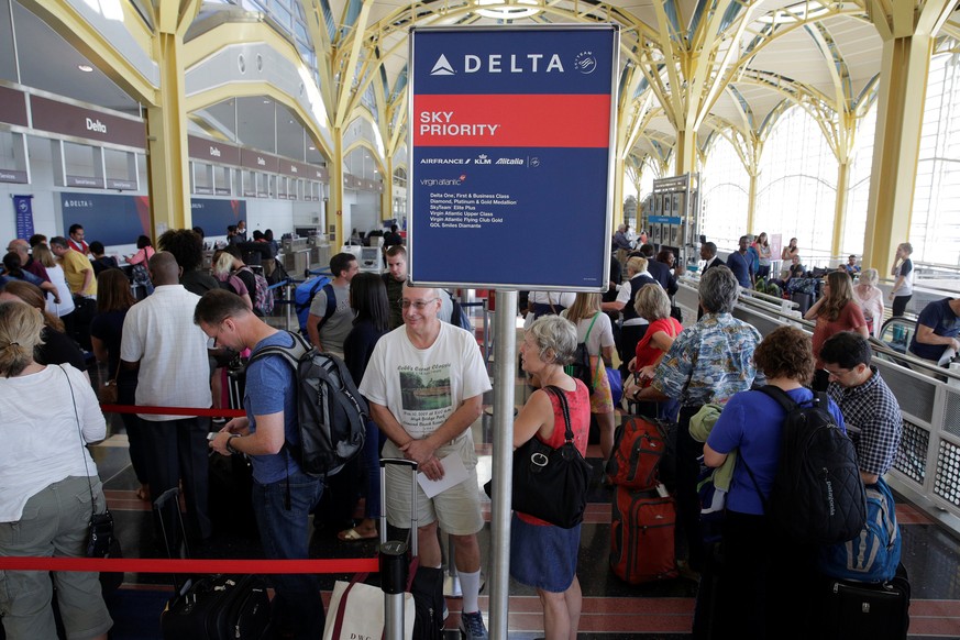 Passengers wait in line to check in after Delta Air Lines computer systems crashed leaving passengers stranded at airports around the globe as flights were grounded at Ronald Reagan Washington Nationa ...