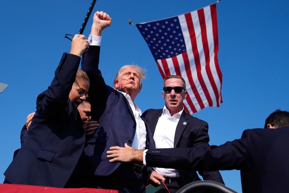 FILE - Republican presidential candidate former President Donald Trump is surrounded by U.S. Secret Service agents after being shot at a campaign rally, July 13, 2024, in Butler, Pa. (AP Photo/Evan Vu ...