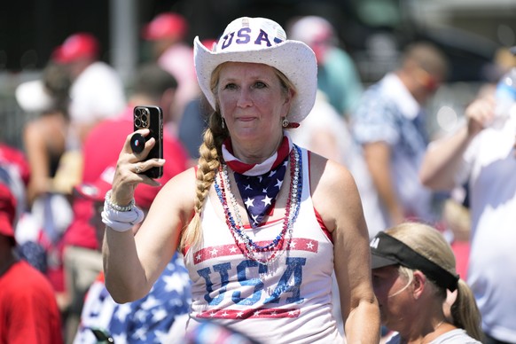 Melody Bruckner, of Waunakee, Wisc., takes a photo while waiting for President Donald Trump to arrive at a rally, Thursday, July 3, 2025, in Des Moines, Iowa. (AP Photo/Charlie Neibergall)
Trump