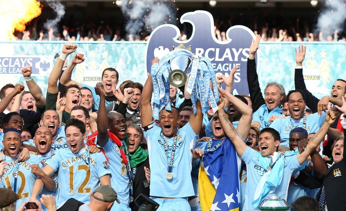 Manchester City team members celebrate with the English Premier League trophy after their team's 3-2 win over Queens Park Rangers at The Etihad Stadium, Manchester, England, Sunday May 13, 2012.  ...