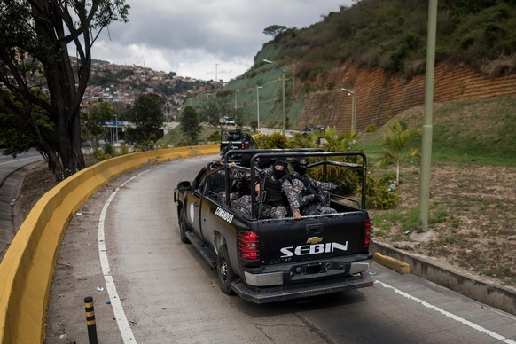 epa06441221 Members of the Bolivarian Armed Forces head to the location in an operation against a terrorist group in the El Junquito neighborhood in Caracas, Venezuela, 15 January 2018. Venezuelan a ...