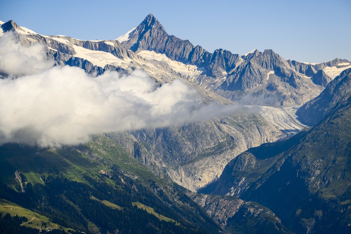 Le glacier de Fiesch (Fieschergletscher) en Valais est visible entre les montagnes valaisannes le jeudi 20 juillet 2023. (KEYSTONE/Jean-Christophe Bott)