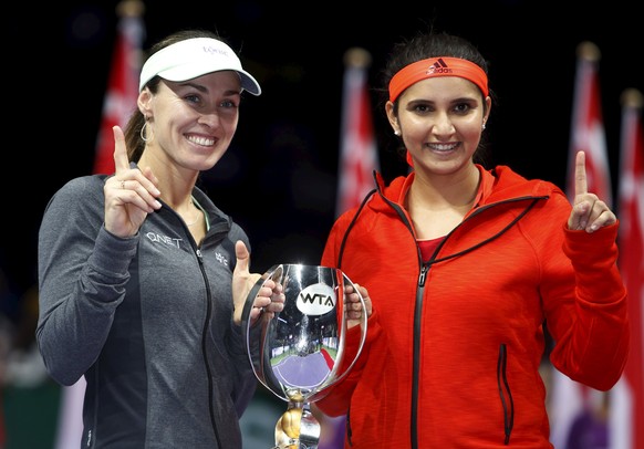 Martina Hingis of Switzerland and Sania Mirza of India celebrate with their trophy after defeating Garbine Muguruza of Spain and compatriot Carla Suarez Navarro in their women&#039;s doubles finals te ...