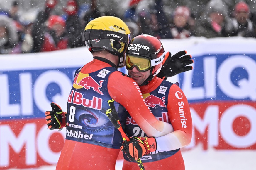 epa10419991 Beat Feuz (R) of Switzerland and Niels Hintermann of Switzerland react in the finish area during the Men&#039;s Downhill race at the FIS Alpine Skiing World Cup at the Streif ski course in ...