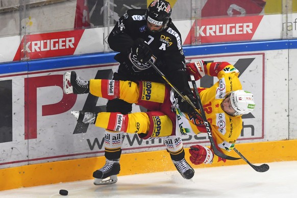 Lugano&#039;s player Philippe Furrer, left, fights for the puck with Bienne&#039;s player Mathieu Tschantre, right, during the sixth match of the semifinal of National League Swiss Championship 2017/1 ...