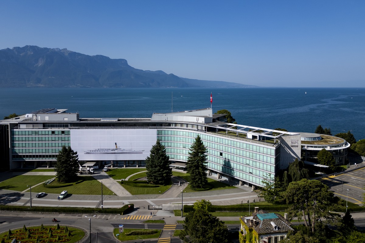 Workers hang a giant photograph "Belle epoque, 2024" by Swiss artist Vincent Jendly, showing the steam boat ?La Suisse?, on the facade of the Nestle company headquarters for the next biennia ...