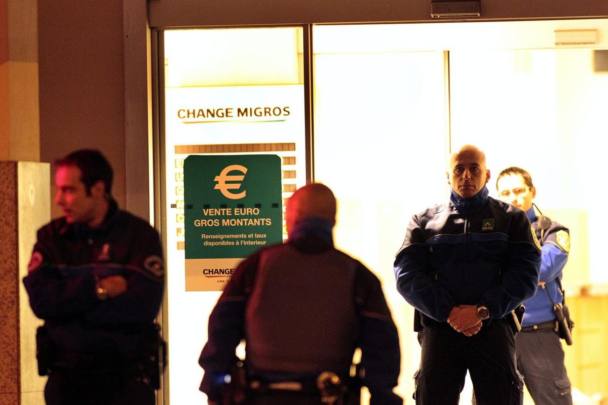 Des gendarmes de la police genevoise bouclent l'entree du Change Migros ou a eu lieu un brigandage et une fusillade avec des voleurs, ce vendredi 26 novembre 2010 a Chene-Boug pres de Geneve. (KE ...