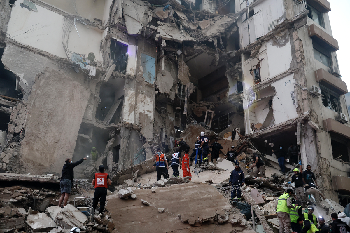 First responders search for missing people under the rubble of a partially destroyed residential building following an Israeli air strike, in the Tallet al-Khayat neighborhood of Beirut, Lebanon, 08 A ...