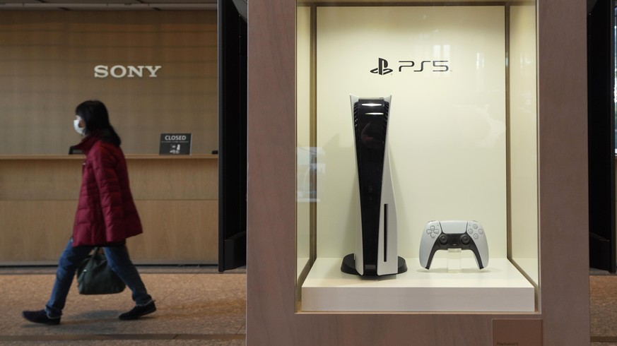 epa08983307 A visitor walks past a Playstation 5 displayed at the headquarters of Sony Corp. in Tokyo, Japan, 03 February 2021. Sony will announce its 2020 Q3 results, as well as results from April to ...