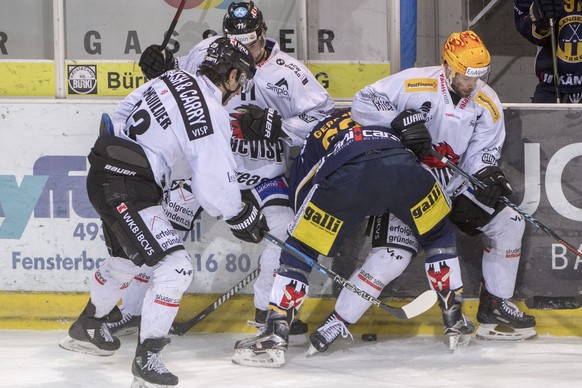 Langenthals Tom Gerber, Mitte, im Duell mit Visps Mark Van Guilder, links, Luca Camperchioli, Mitte und Dan Kissel, rechts, im ertsen Playoff-Viertelfinalspiel der Swiss League zwischen dem SC Langent ...