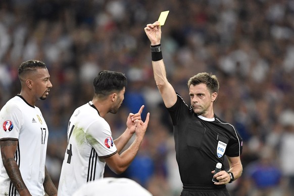 Referee Nicola Rizzoli shows a yellow card to Germany&#039;s Emre Can, center, during the Euro 2016 semifinal soccer match between Germany and France, at the Velodrome stadium in Marseille, France, Th ...