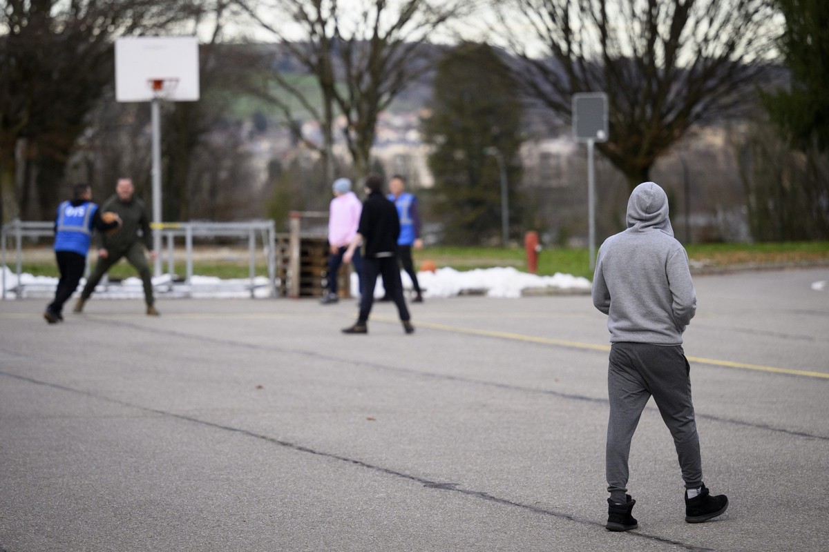 Un refugie marche dans la court alors que des employes de ORS (Organisation for Refugee Services) jouent au basket dans la court de la caserne lors d'une visite de presse, organisee par le Secret ...