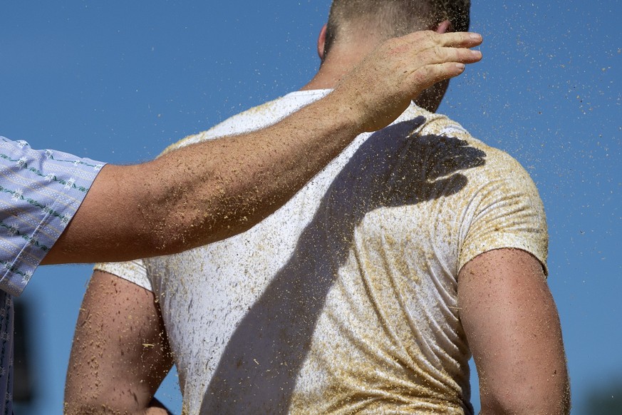 Simon Anderegg, links, wischt den Ruecken von Samuel Brun, nach dem dritten Gang beim Oberaargauischen Schwingfest, am Samstag, 8. Juni 2019, in Grafenried. (KEYSTONE/Peter Klaunzer)