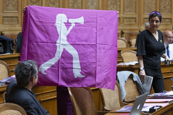 Margret Kiener Nellen, SP-BE, verdeckt, zeigt neben Flavia Wasserfallen, SP-BE, rechts, eine Flagge des Frauenstreiks im Nationalrat, waehrend der Sommersession der Eidgenoessischen Raete, am Freitag, ...