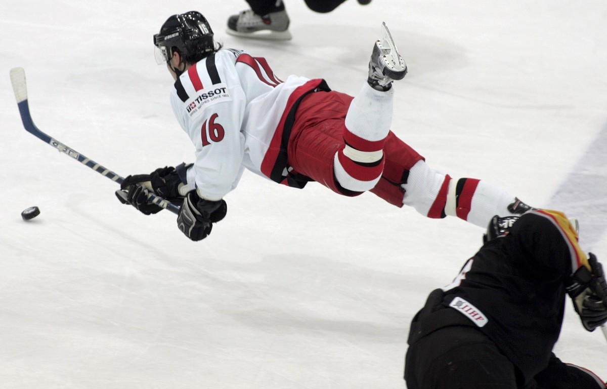 Switzerland's Andres Ambuehl flies fighting for the puck, during the qualifying group E match between Germany and Switzerland, at the 68th Ice Hockey World Championship, Tuesday, May 4, 2004 in P ...