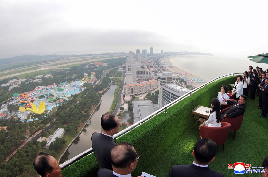 In this photo provided by the North Korean government, North Korean leader Kim Jong Un, sitting center, with his wife Ri Sol Ju, rear, and daughter tours the Wonsan-Kalma coastal tourist zone in North ...