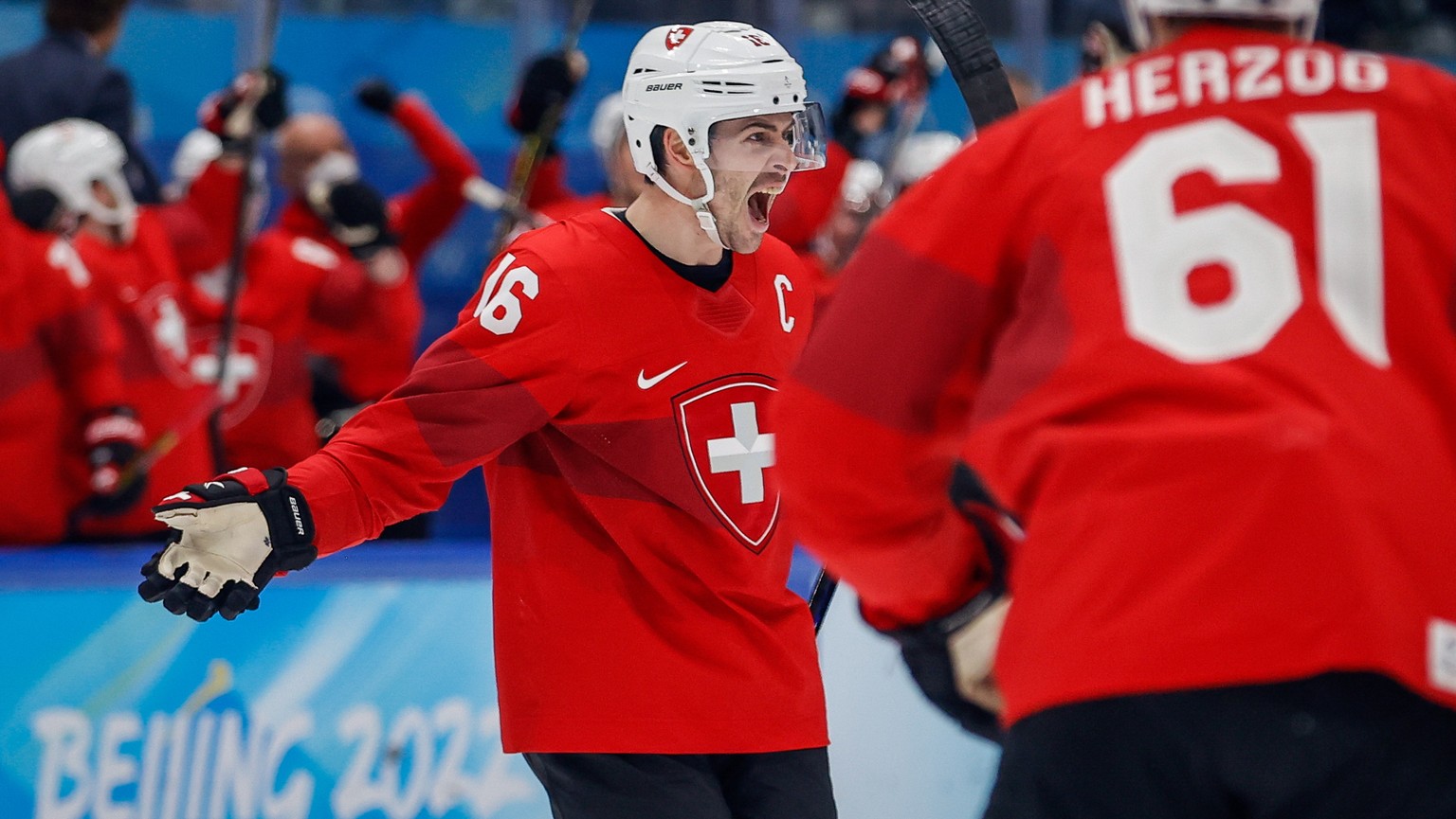 epa09758420 Raphael Diaz (L) of Switzerland celebrates after scoring during the Men&#039;s Ice Hockey Qualification Play-off match between Czech Republic and Switzerland at the Beijing 2022 Olympic Ga ...