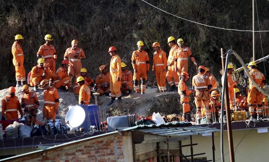 Rescuers rest at the site of an under-construction road tunnel that collapsed in Silkyara in the northern Indian state of Uttarakhand, Friday, Nov. 24, 2023. Rescuers are racing to evacuate 41 constru ...