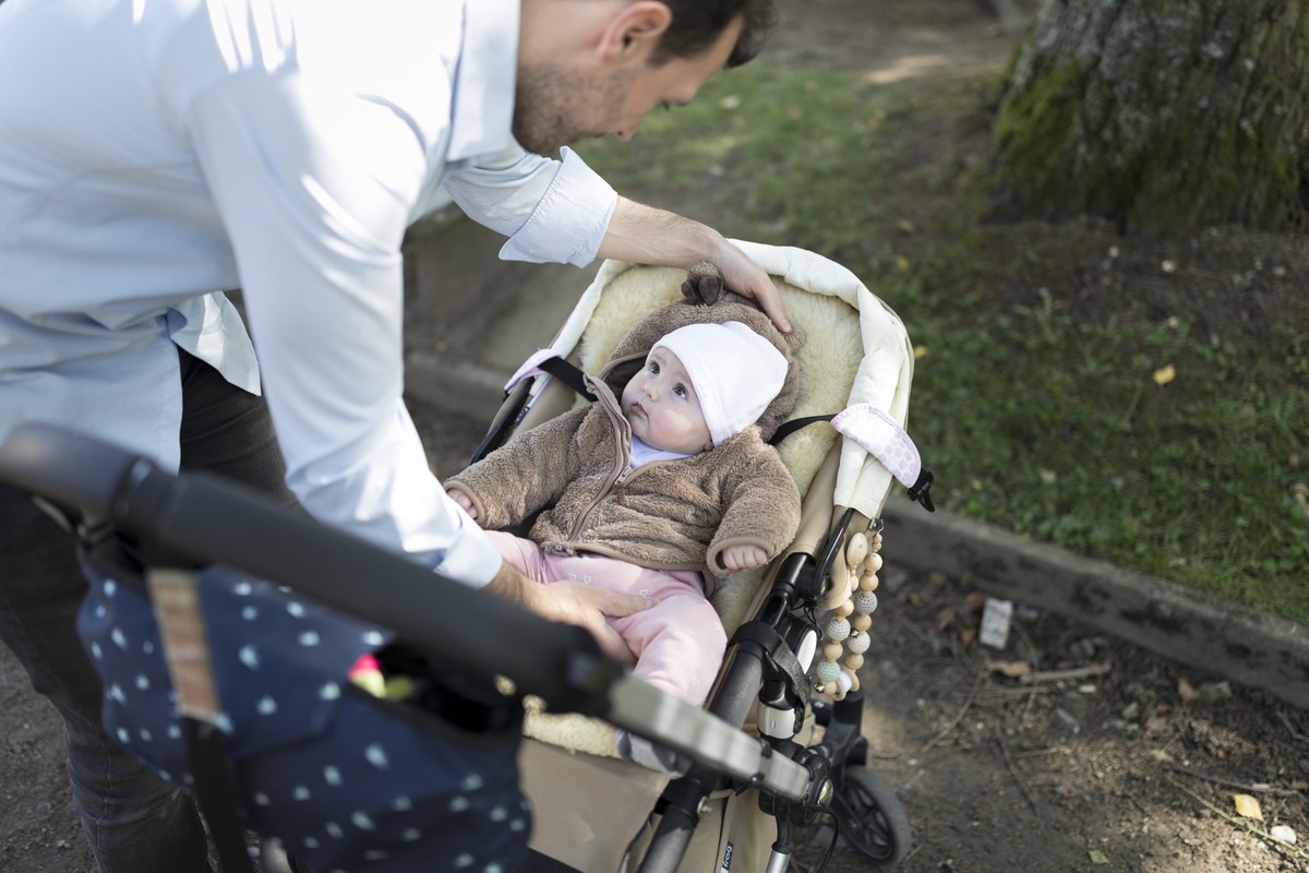 ARCHIV  ZUM THEMA VATERSCHAFTSURLAUB STELLEN WIR IHNEN FOLGENDES BILDMATERIAL ZUR VERFUEGUNG -- A father places his five-month-old daughter into a stroller, pictured in Kilchberg, Canton of Zurich, S ...