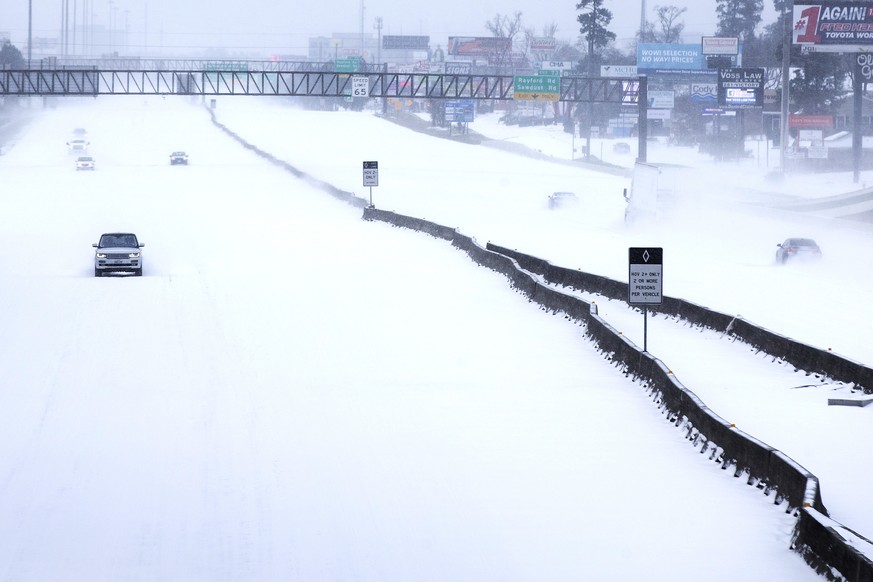 FILE - In this Monday, Feb. 15, 2021 file photo, Traffic is sparse on the snow-covered Interstate 45 near The Woodlands Parkway following an overnight snowfall in The Woodlands, Texas, as temperatures ...