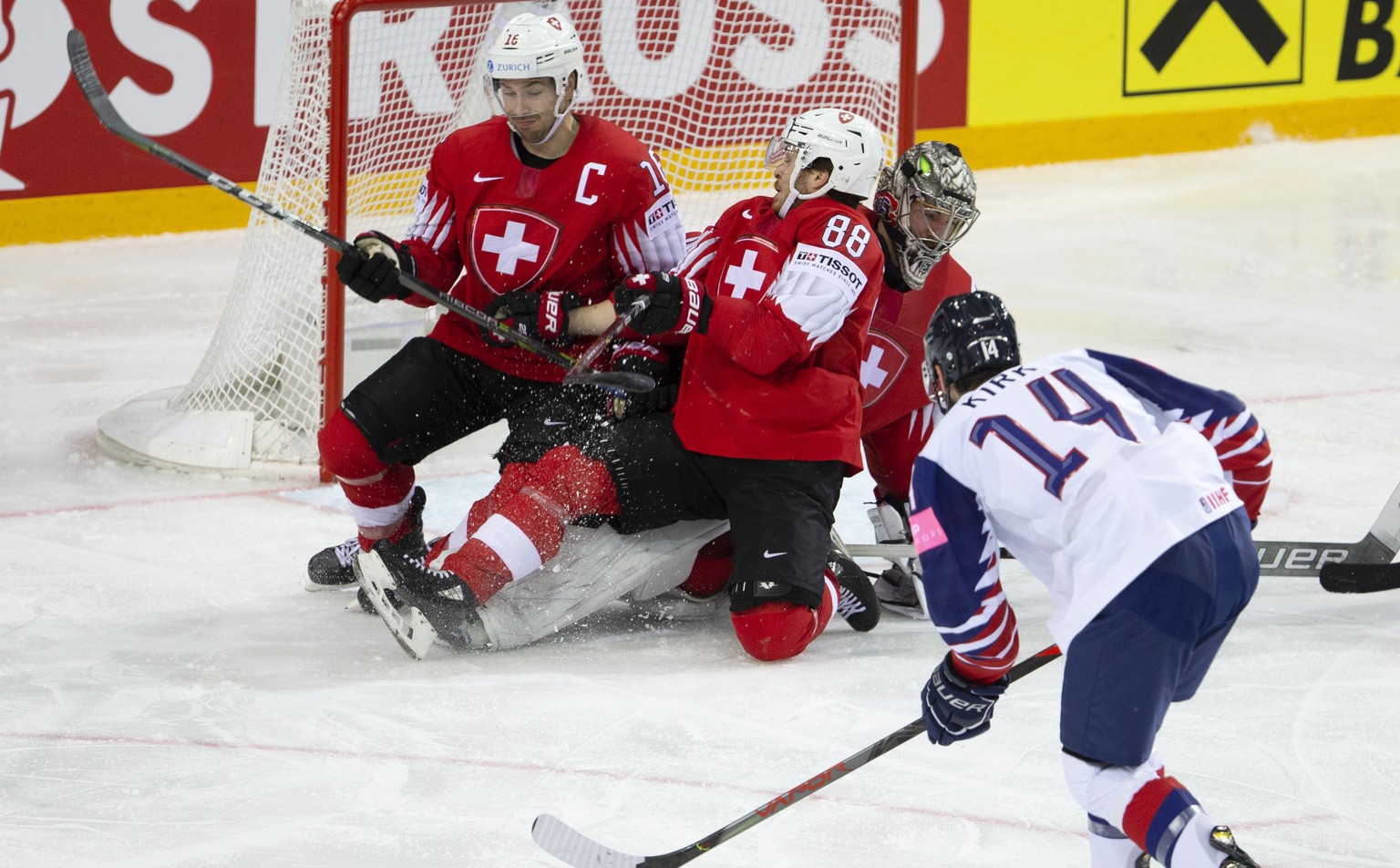 Great Britain&#039;s forward Liam Kirk #14 scores the 2:2 against Switzerland&#039;s players defender Raphael Diaz, left, forward Christoph Bertschy #88 and goaltender Reto Berra, during the IIHF 2021 ...